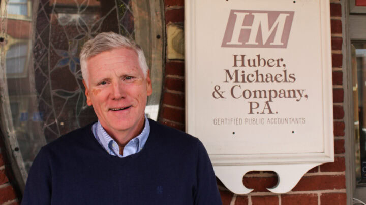 Professional accountant standing outside Huber Michaels & Company office building.