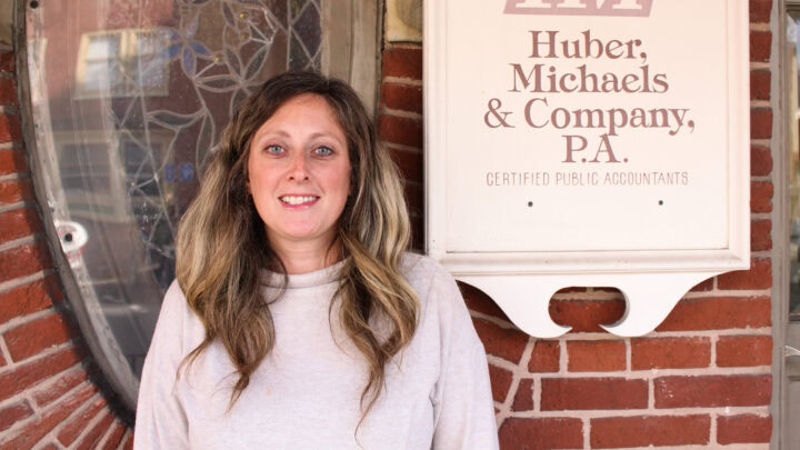 Huber Michaels & Company CPA office exterior with smiling woman in front.